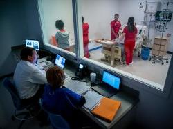 护理学教授和教师在模拟实验室观察学生.
