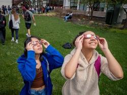 Physics majors Mariana Pereira and Jasmine Valencerina looking cool in their eclipse glasses. [Photo by John LaRosa.]